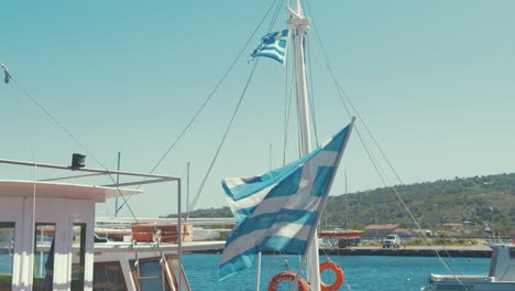 Greek-flags-on-stern-of-boat-blowing-in-wind-slow-motion-sunshine