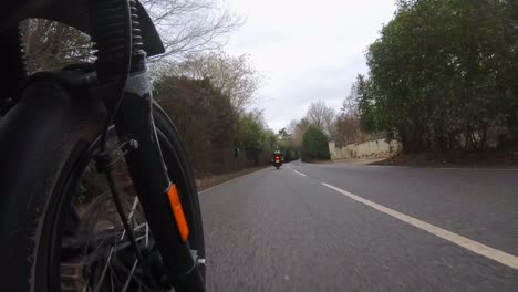 low angle shot following a motor biker on a country lane