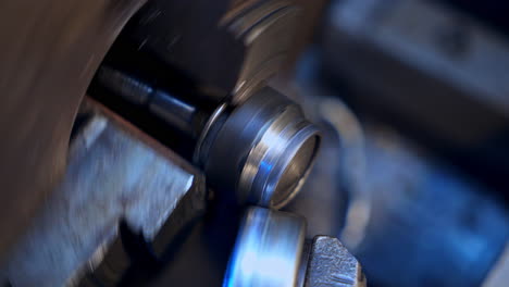 two attached machine pieces turning to make screw-thread on the detail. rotating mechanism on the turner's equipment. close up.