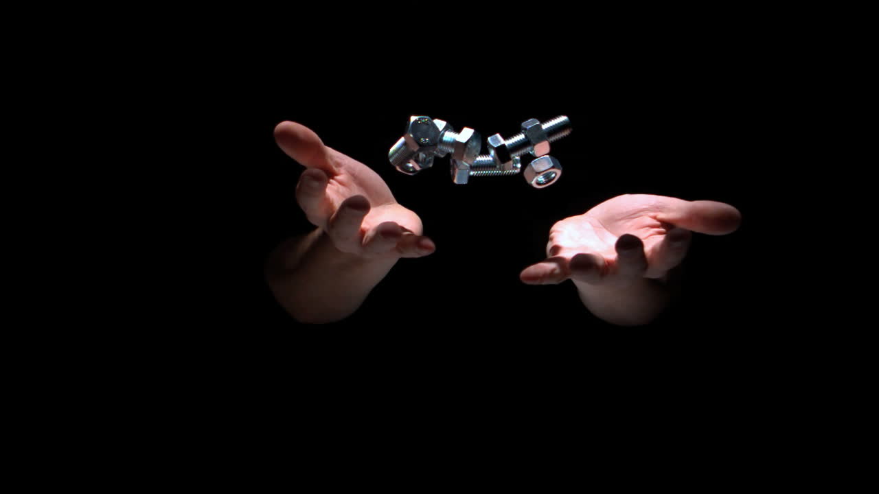 스크루와 볼트를 던지는 사람의 손