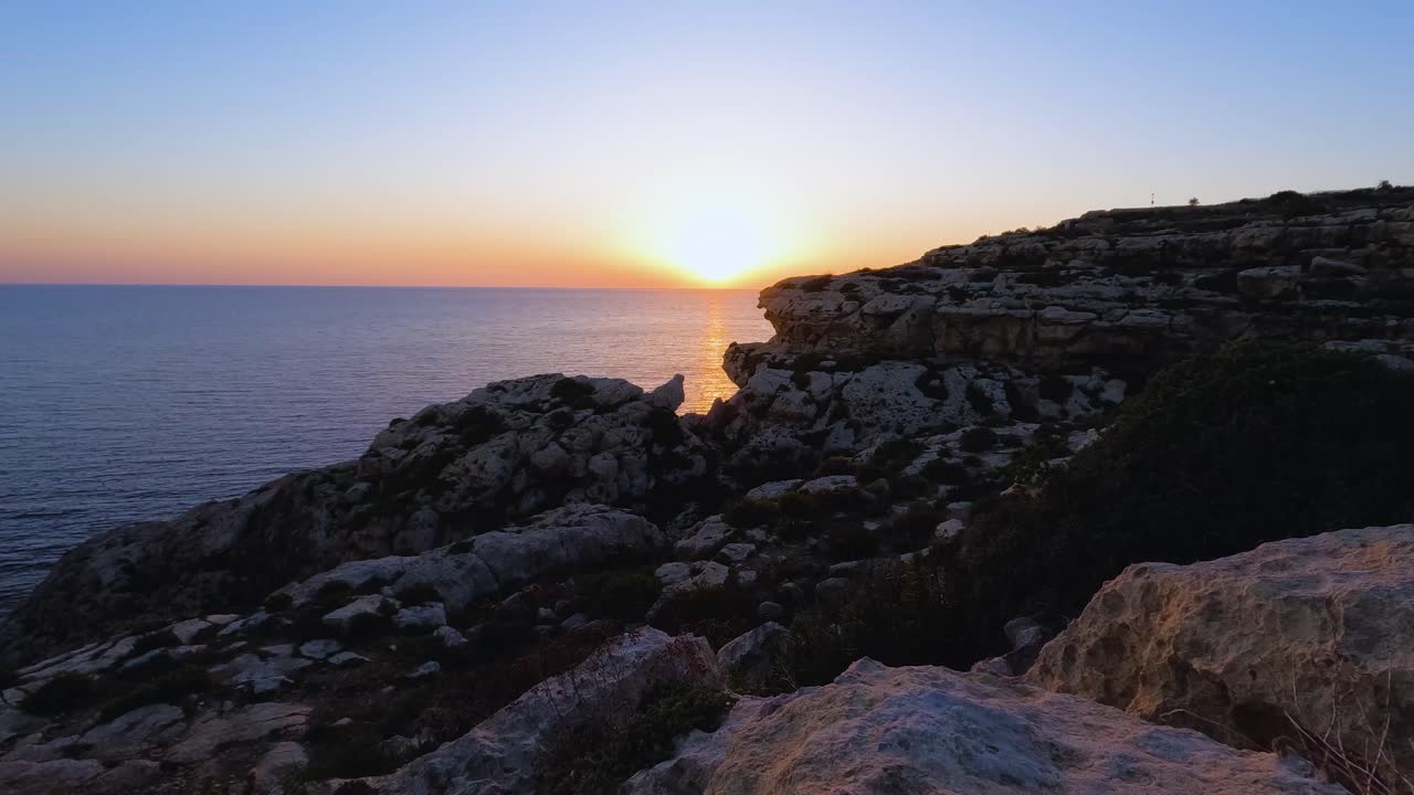 expansivos acantilados marinos enmarcan una impresionante puesta de sol en este gran ángulo de lapso de tiempo