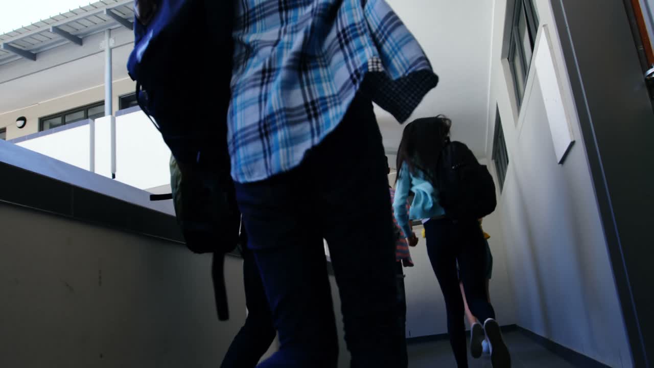 grupo de compañeros de clase corriendo en el pasillo