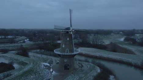 aerial view of nooit volmaakt flour mill on the bank of linge river in wintertime at gorinchem, netherlands