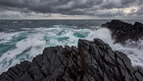 stormy ocean waves crashing on dark rocks
