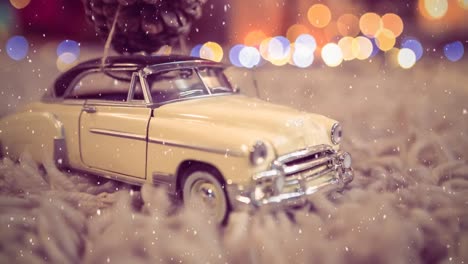 model car with a fir cone on its roof on a carpet combined with falling snow