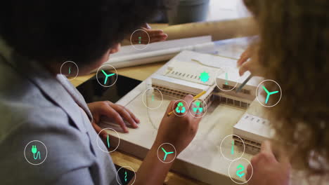 collaborating diverse team planning architectural model with sustainability icons animation