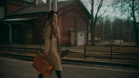 mujer sonriente caminando en la estación de tren