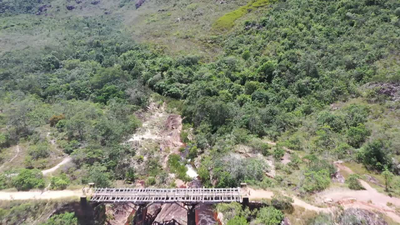 vista aérea de drones de un viejo puente con un río marrón que fluye debajo