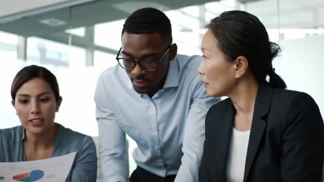 a focused team discusses strategic plans in a modern office setting, analyzing data and collaborating on solutions to drive business success