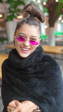 smiling young woman in pink glasses