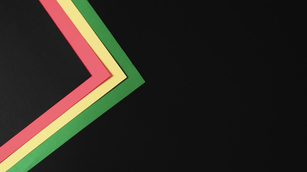 Video of red, yellow and green papers with copy space on black background