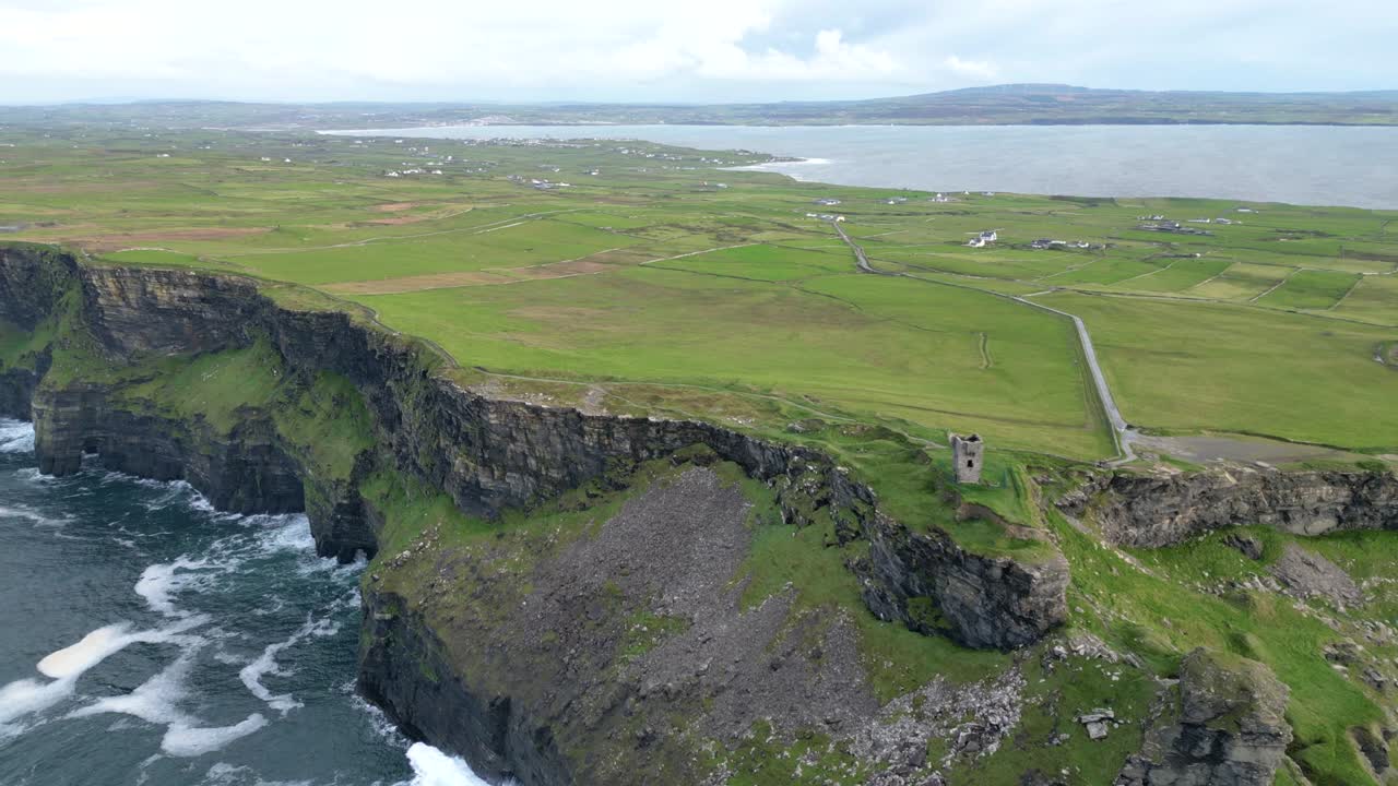 Aerial view of Cliffs of Moher with Tower at Hag's Head and ocean waves in Ireland