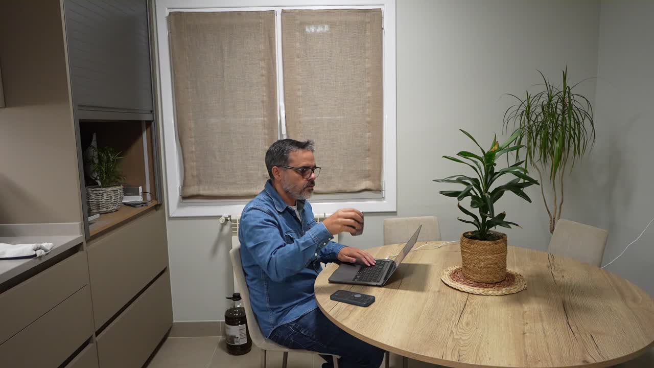 Homem a trabalhar no portátil em casa