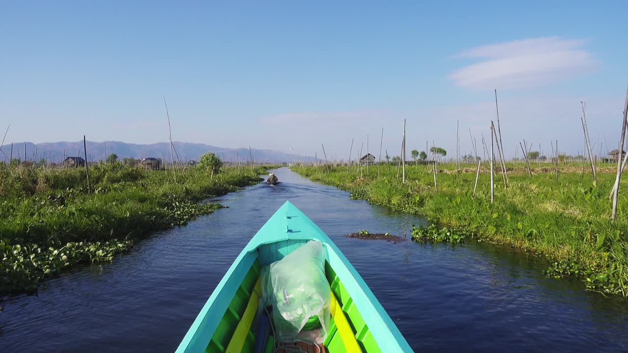 인레 호수 에 있는 떠다니는 정원 들 사이 에서 배 가 떠다니고 있다