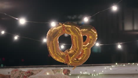 fiesta de cumpleaños número 30 globos dorados flotando en el techo por la noche