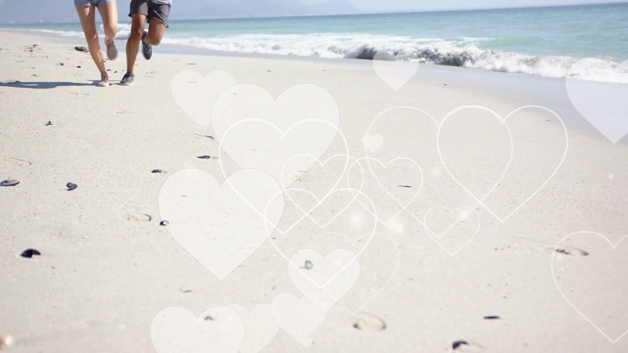 Couple entering left, jogging for fitness along beach while heart-shaped bokeh overlaying sand