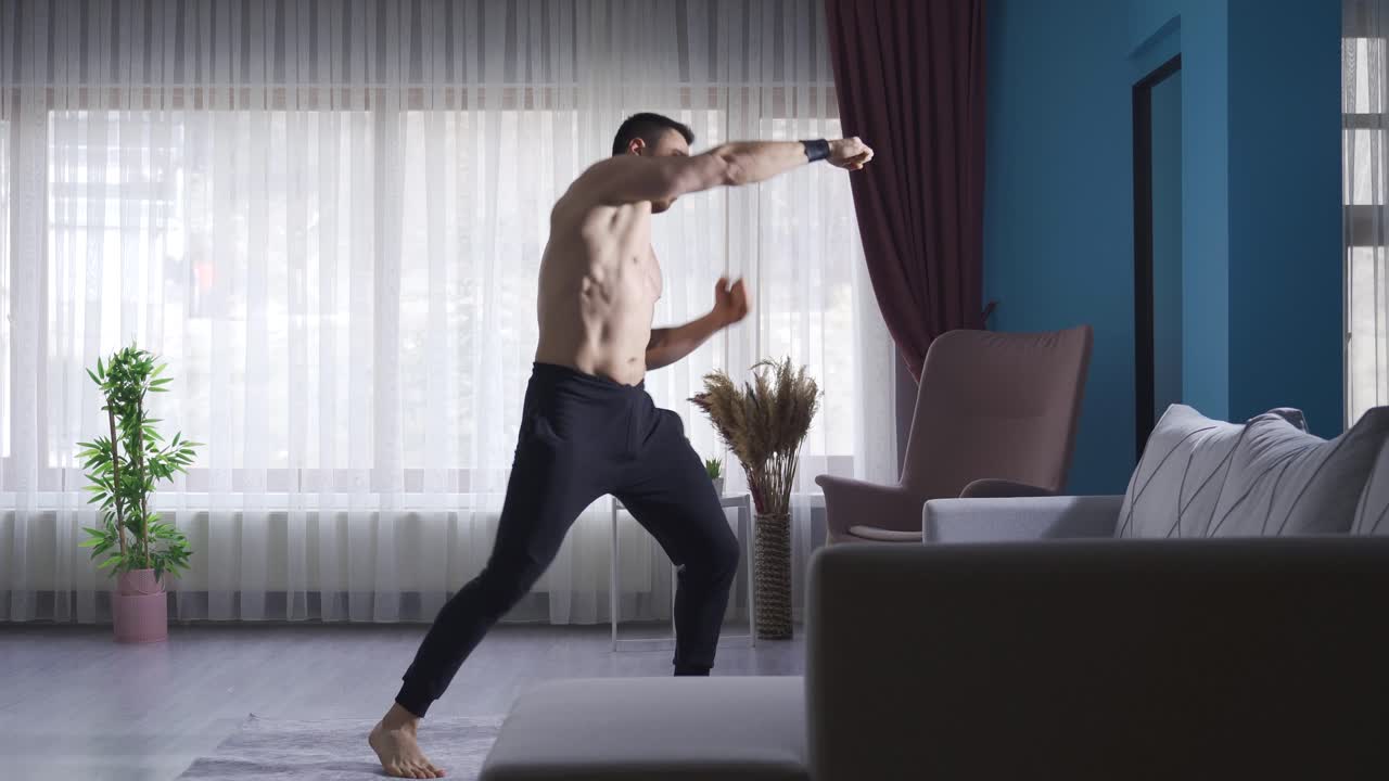 joven shadowboxing en casa para mantener su forma física y la forma física