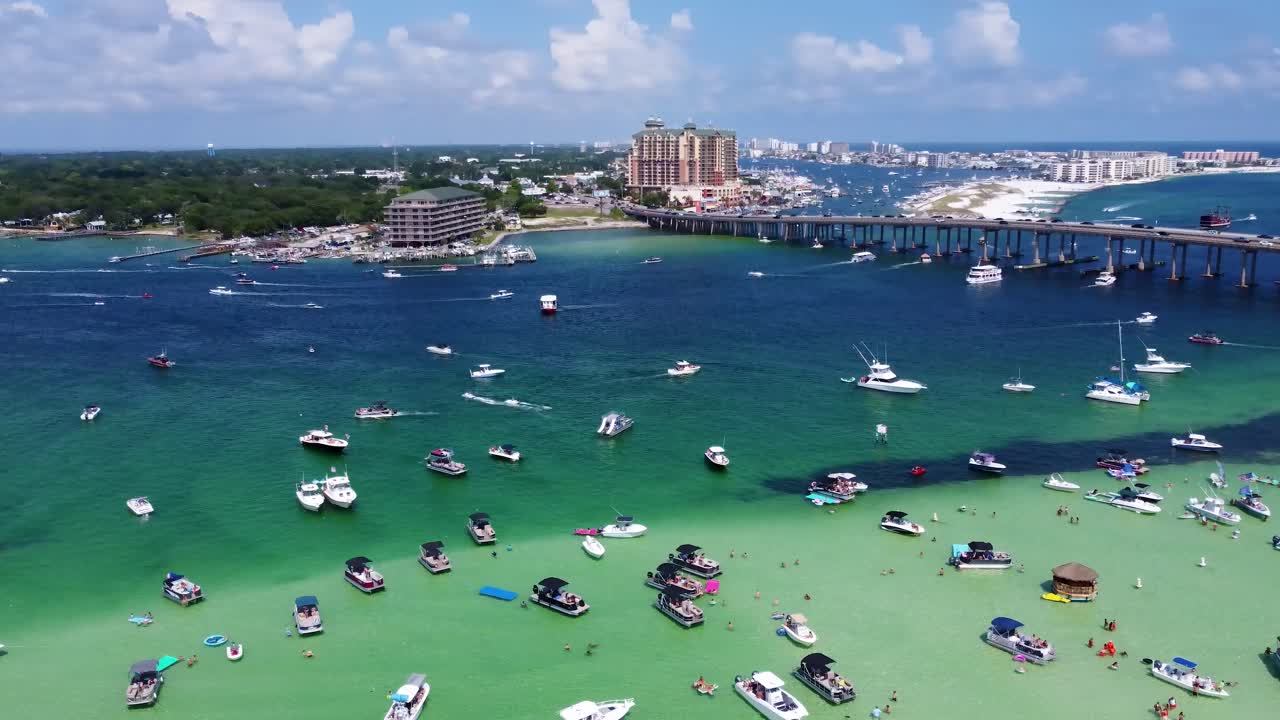 Cinematic Aerial View of Crab Island Off of Destin Florida. Crowd of people along with Vibrant fleet of yachts, pontoon boats adorn Crab Island, Florida's aerial view. Drone Shot of Crab Island Destin