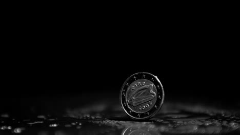 two euro coin revolving on black background close up