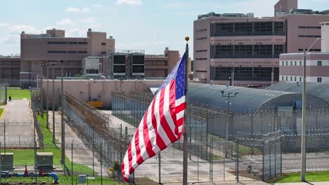 american flag waving in front of secure usa prison