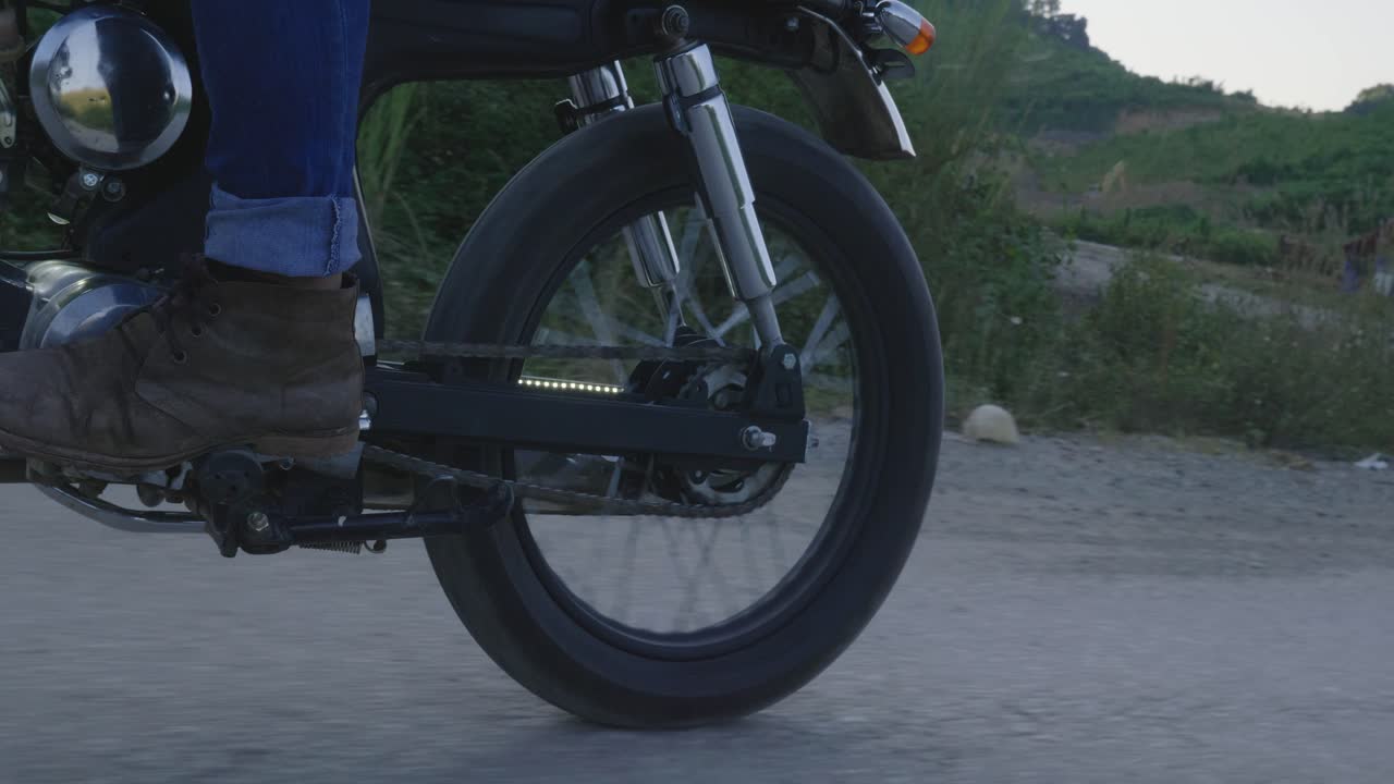 A Person Riding a Vintage Motorcycle on a Dirt Road