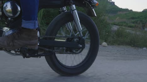 a person riding a vintage motorcycle on a dirt road