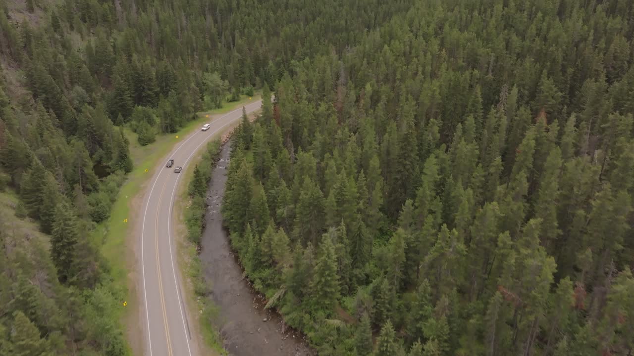 Drone shot of a car driving up a mountain in Canada