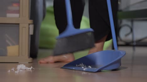 sweeping garbages debris with broom stick and scoop in bed room