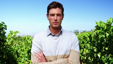 Portrait-of-man-standing-with-arms-crossed-in-vineyard