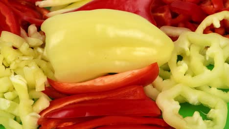 yellow and red bell peppers are cut in different ways. healthy food concept. preparing vegetable for salad. loop motion. side view. rotation 360.