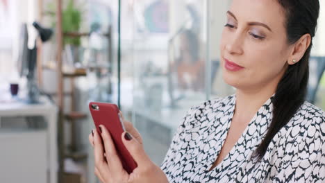 Mature-Business-woman-using-smart-phone-app-connecting-digital-device-in-modern-office