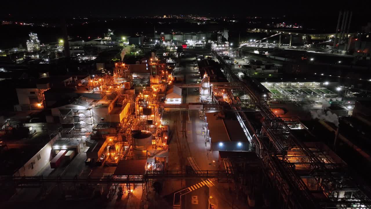 Flashing lights of American factory in Richmond, Virginia at night. AERIAL wide shot. Dupont Spruance Manufacturing site
