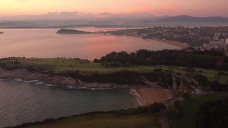 santander spain panoramic aerial drone view of the cityscape with the lighthouse over the cliff and sand beach during sunset
