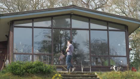 man jumps in excitement receiving good news on phonecall beside cabin