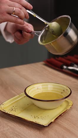 chef pouring soup into a bowl