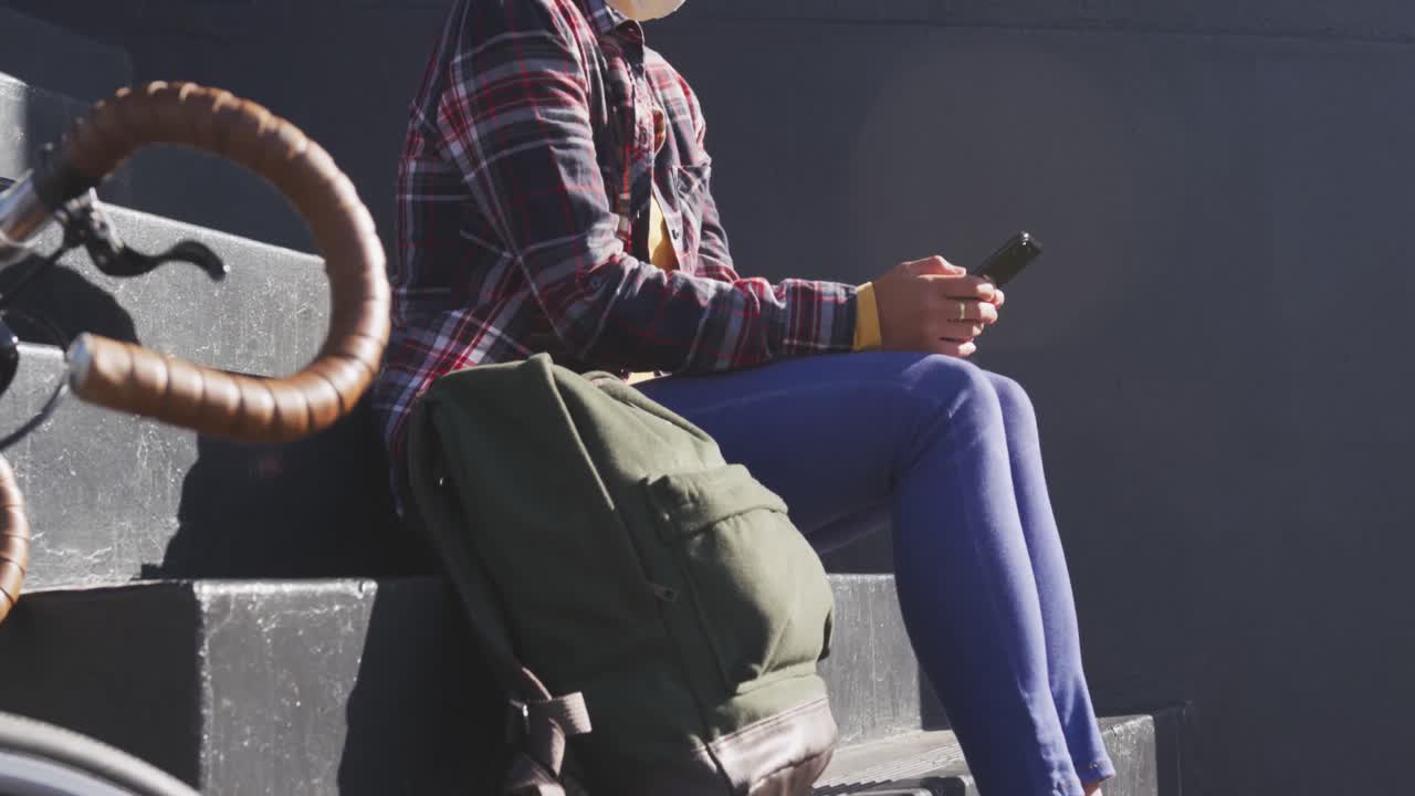Mixed race woman wearing medical coronavirus mask on the street