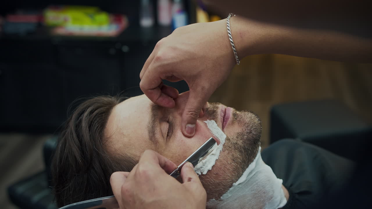 Nærbillede af en mand, der bliver barberet i en barbersalon