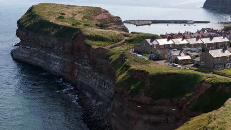 aerial drone view of staithes harbour on the north yorkshire coast with river,houses, boats on a sunny morning in august, summertime