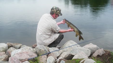 fisherman showing off a pike he just caught