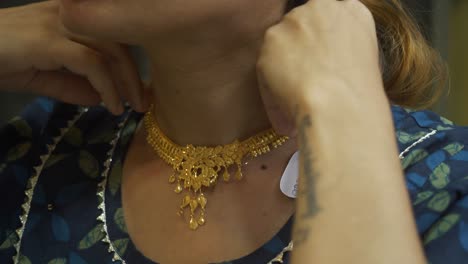 a south asian woman wearing bridal gold jewellery necklace, closeup of neck