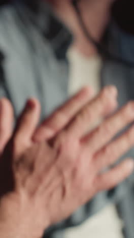 primer plano de dos personas aplaudiendo expresivamente en un estudio de grabación a prueba de sonido durante una actuación. la escena se centra en el movimiento dinámico de las manos frente a un soporte de micrófono