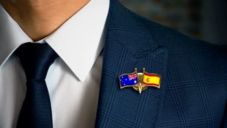 businessman walking towards camera with friend country flags pin australia - spain