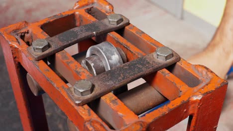 Slow-motion-shot-of-a-metal-bar-bending-clamp-being-operated-by-an-engineer