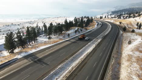 Vehículo-De-Remoción-De-Nieve-Moviéndose-En-La-Autopista-Coquihalla-5-Entre-Merritt-Y-Kamloops-En-Un-Día-Parcialmente-Nublado-En-Invierno,-Laderas-De-Las-Montañas-Cubiertas-De-Nieve