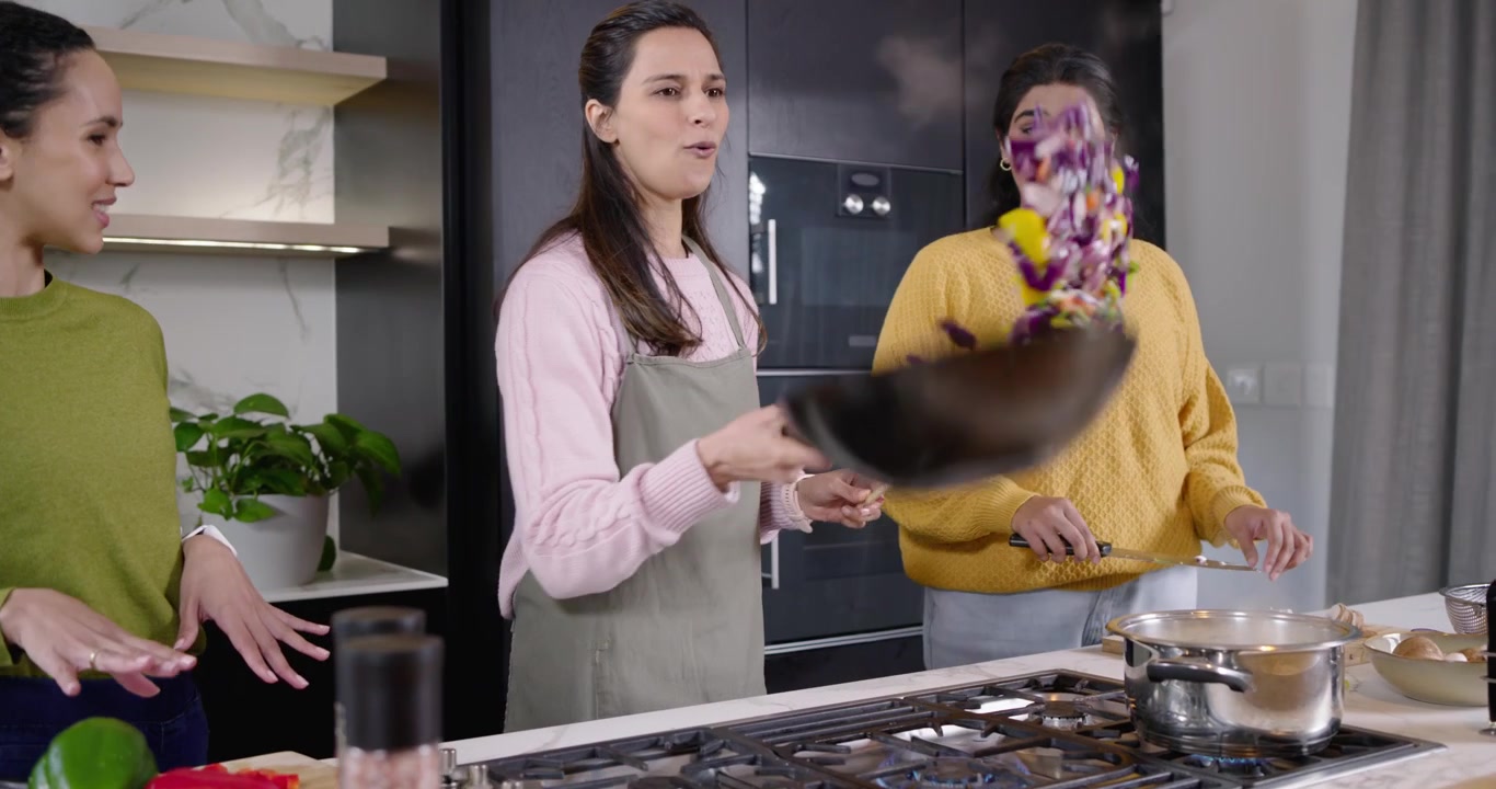 Amies diverses suivant un chef cuisinier montrant un saut de wok dans la cuisine, coupant et moulant des épices.