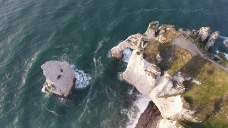 aerial shot over the cliffs and sea in etretat vertical view. sunset