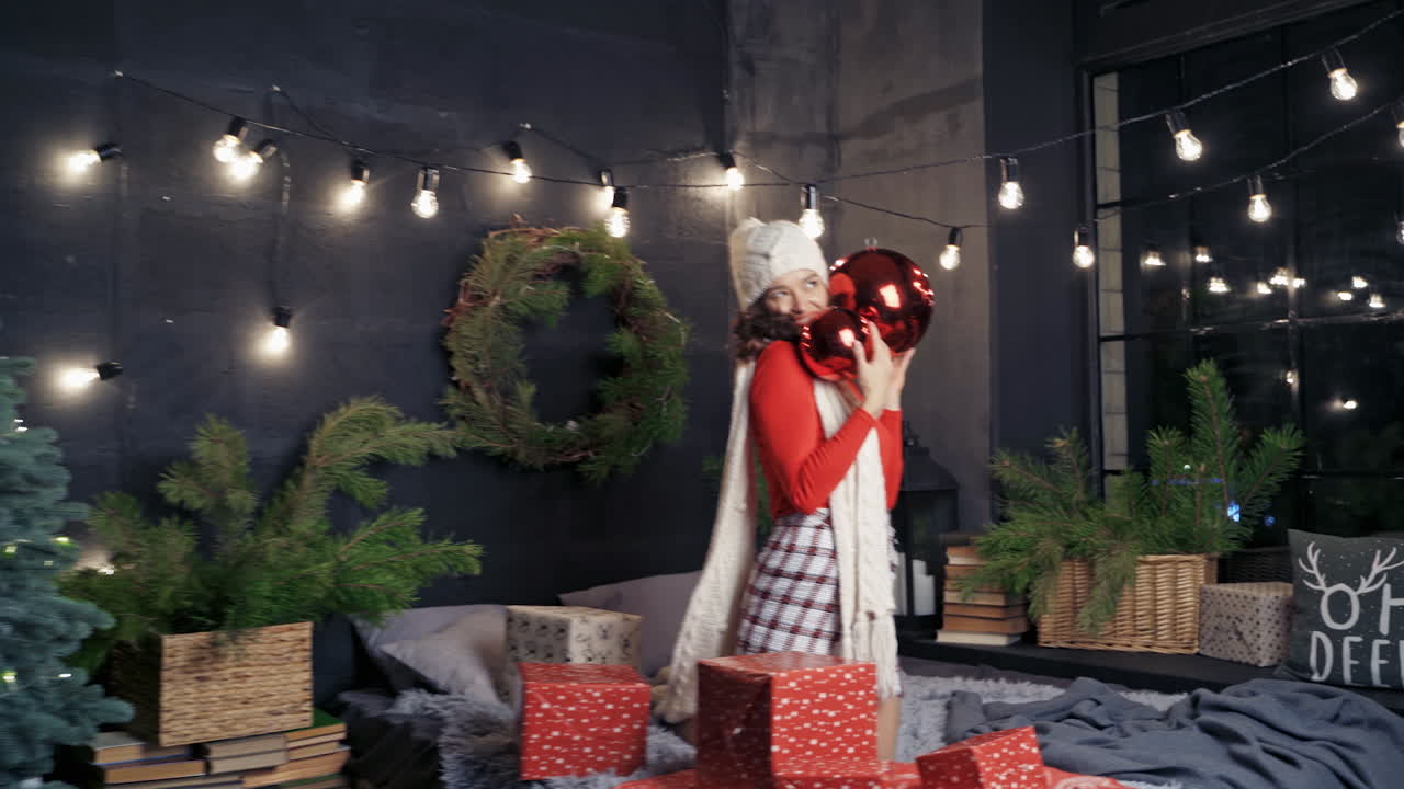 Woman with big christmas balls and presents. Lady in good mood before holidays. New year and Christmas concept.