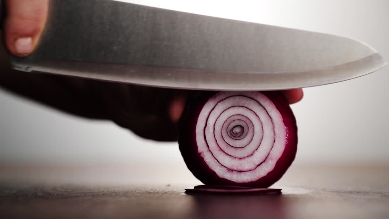 Professional chef cutting onion on wood chopping block