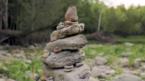 close up of inukshuk cairn stone rock pile in forested landscape