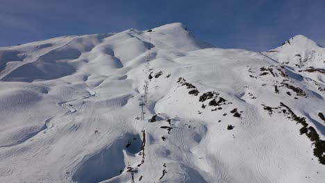 Freestyle-skier-with-a-parachute-on-a-slope---an-aerial-shot-of-the-Swiss-alpine-ski-resort-on-snowy-winter